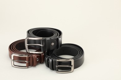 Photo of Three color leather belts on white background, space for text
