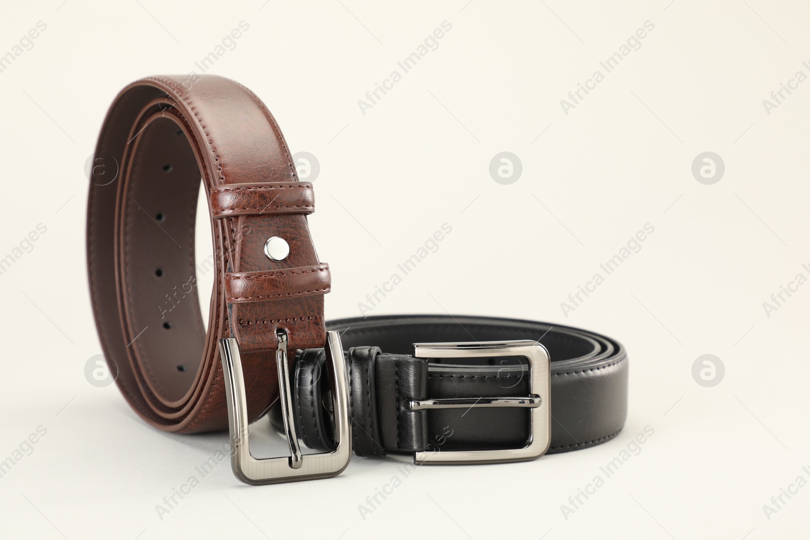 Two leather belts on white background, closeup Photo of Two leather belts on white background, closeup