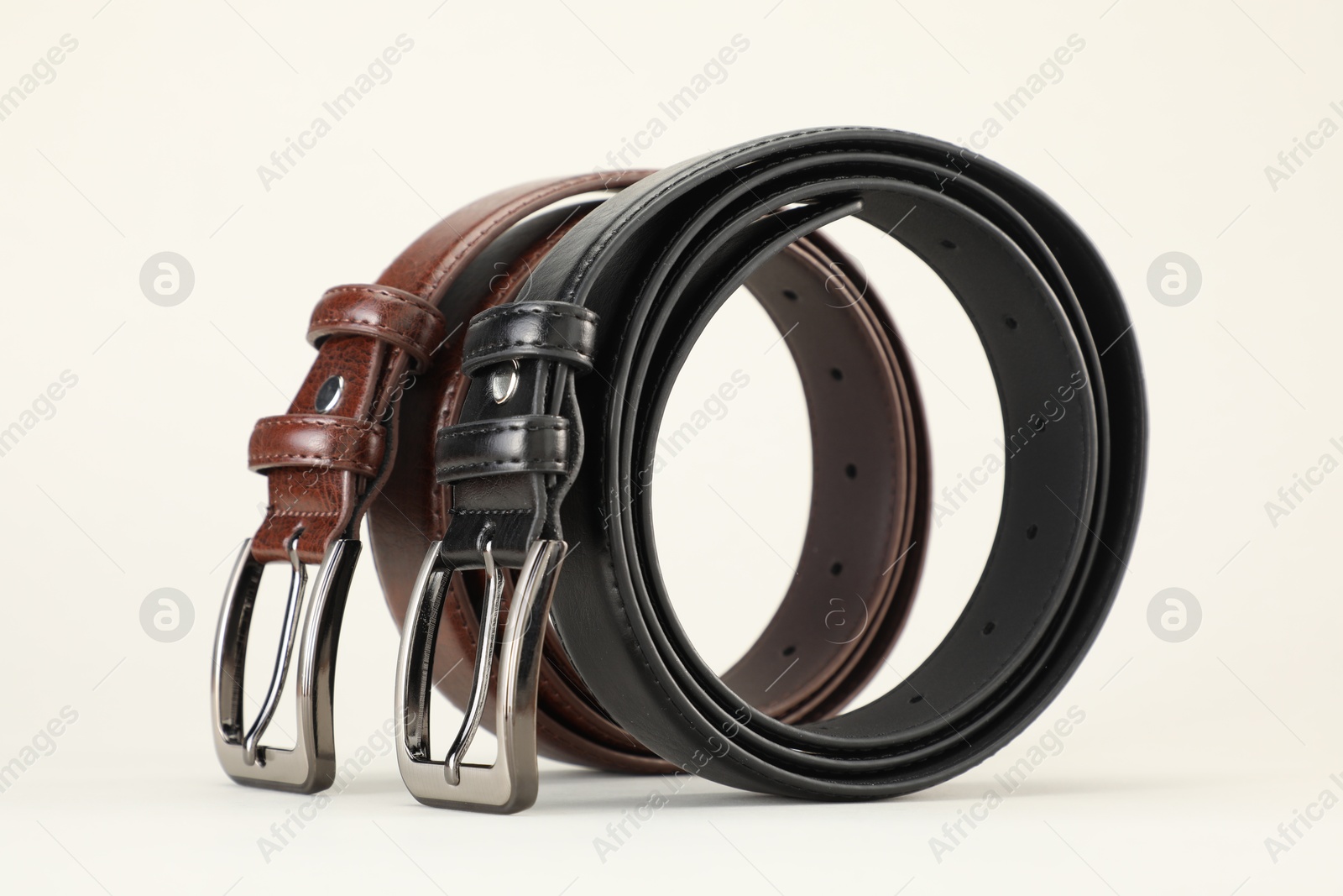 Two leather belts on white background, closeup Photo of Two leather belts on white background, closeup