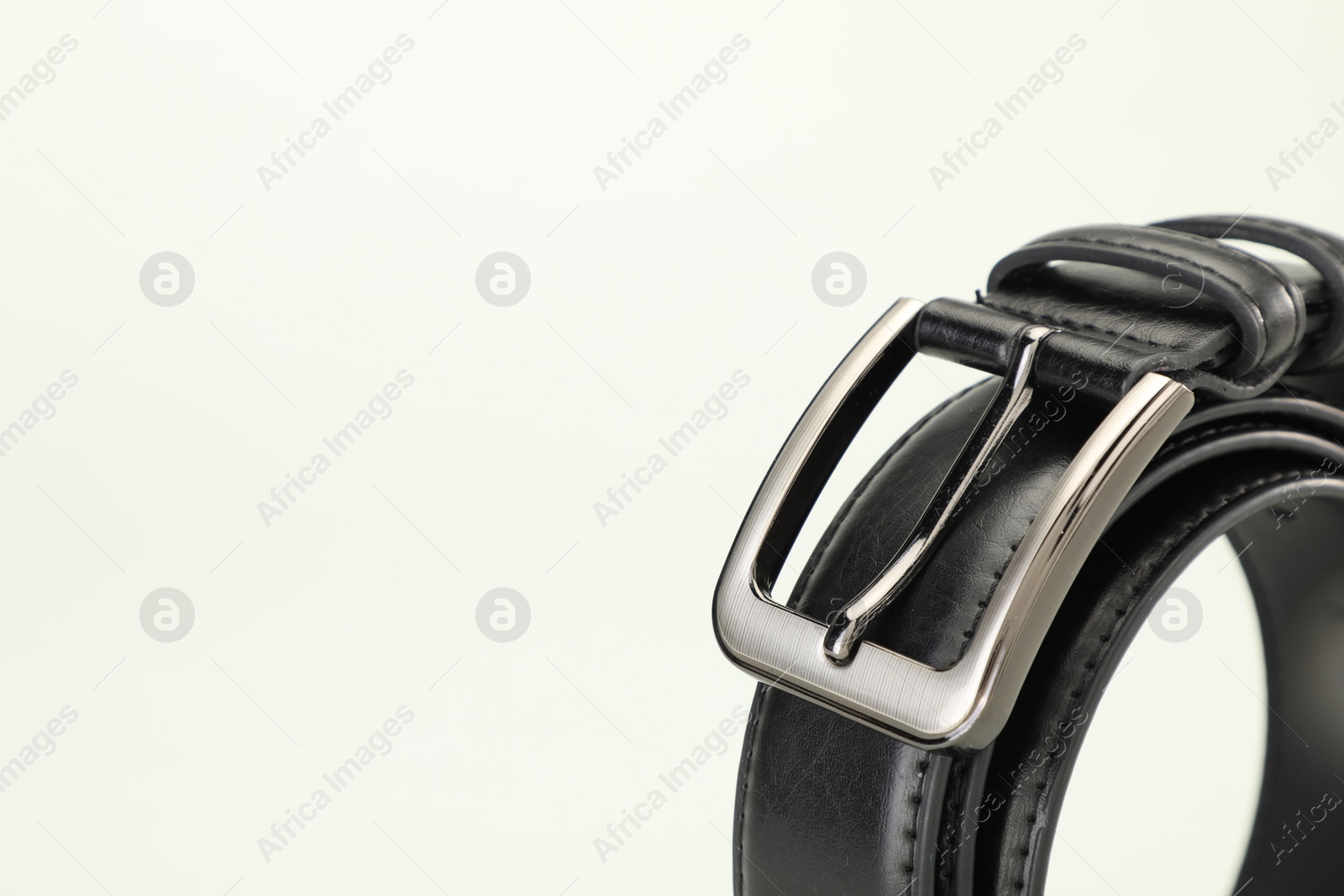One black leather belt on white background, closeup. Space for text Photo of One black leather belt on white background, closeup. Space for text