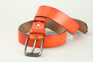 Photo of One orange leather belt on white background, closeup