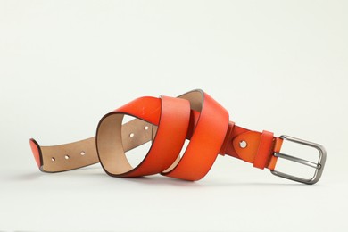 Photo of One orange leather belt on white background