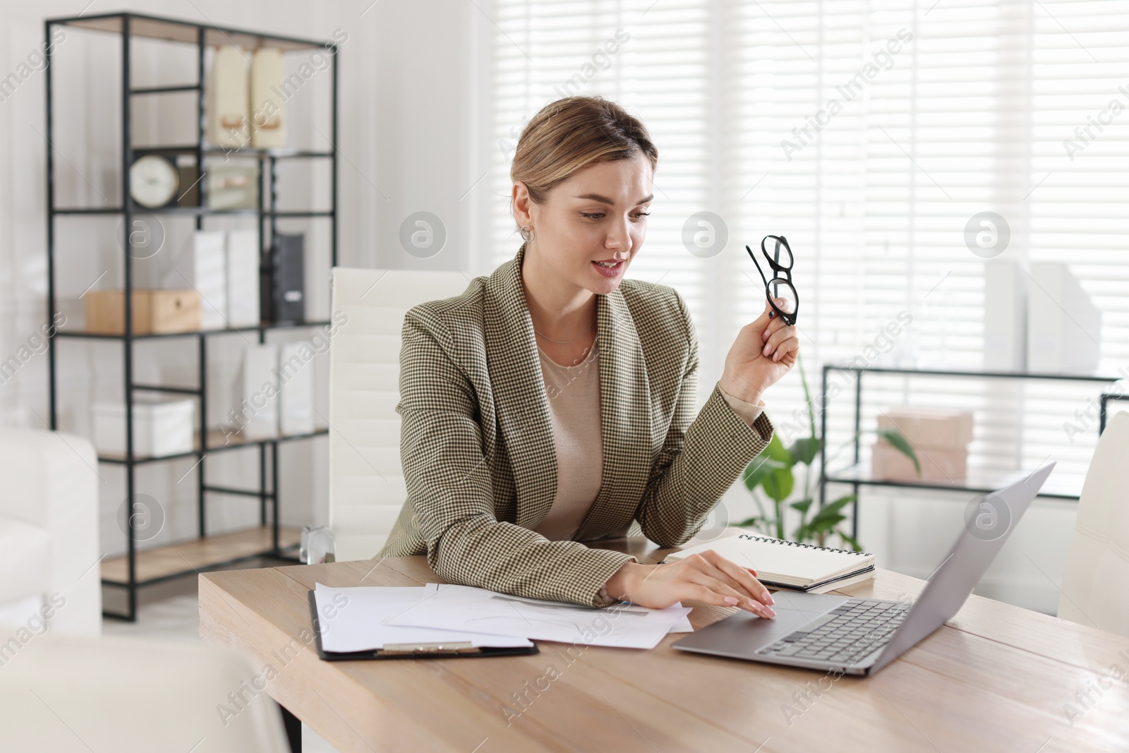 Photo of Professional banker working on laptop at desk in office