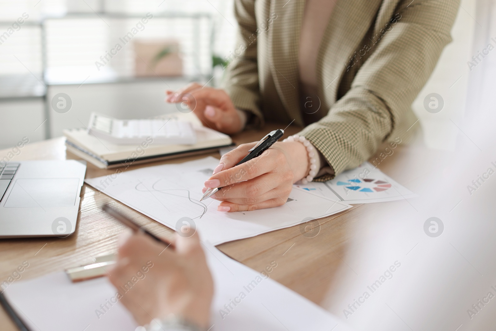 Woman having meeting with banker at desk in office, closeup Photo of Woman having meeting with banker at desk in office, closeup