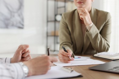 Photo of Woman having meeting with banker at desk in office, closeup