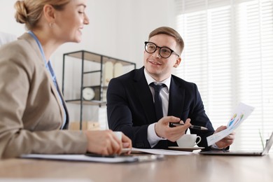 Photo of Woman having meeting with banker at desk in office