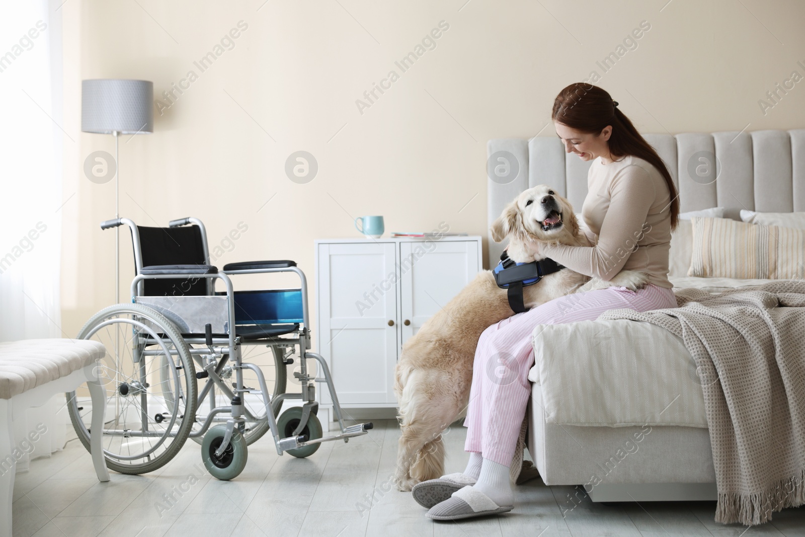 Photo of Woman with disability hugging her service dog at home