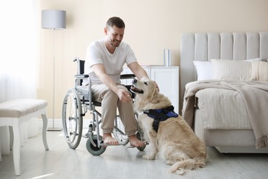 Photo of Man in wheelchair with his service dog at home