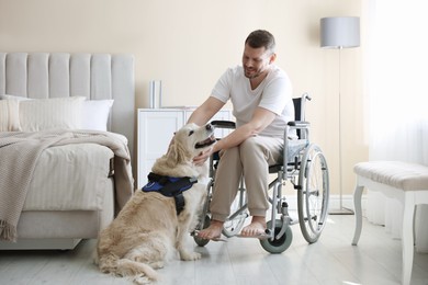 Photo of Man in wheelchair with his service dog at home