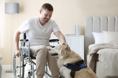 Photo of Man in wheelchair with his service dog at home
