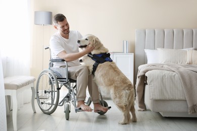 Photo of Man in wheelchair with his service dog at home