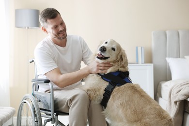 Photo of Man in wheelchair with his service dog at home