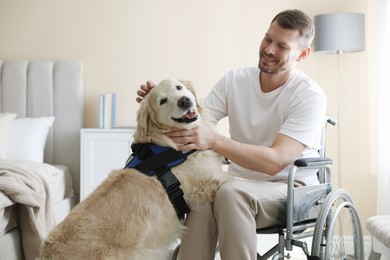 Photo of Man in wheelchair with his service dog at home