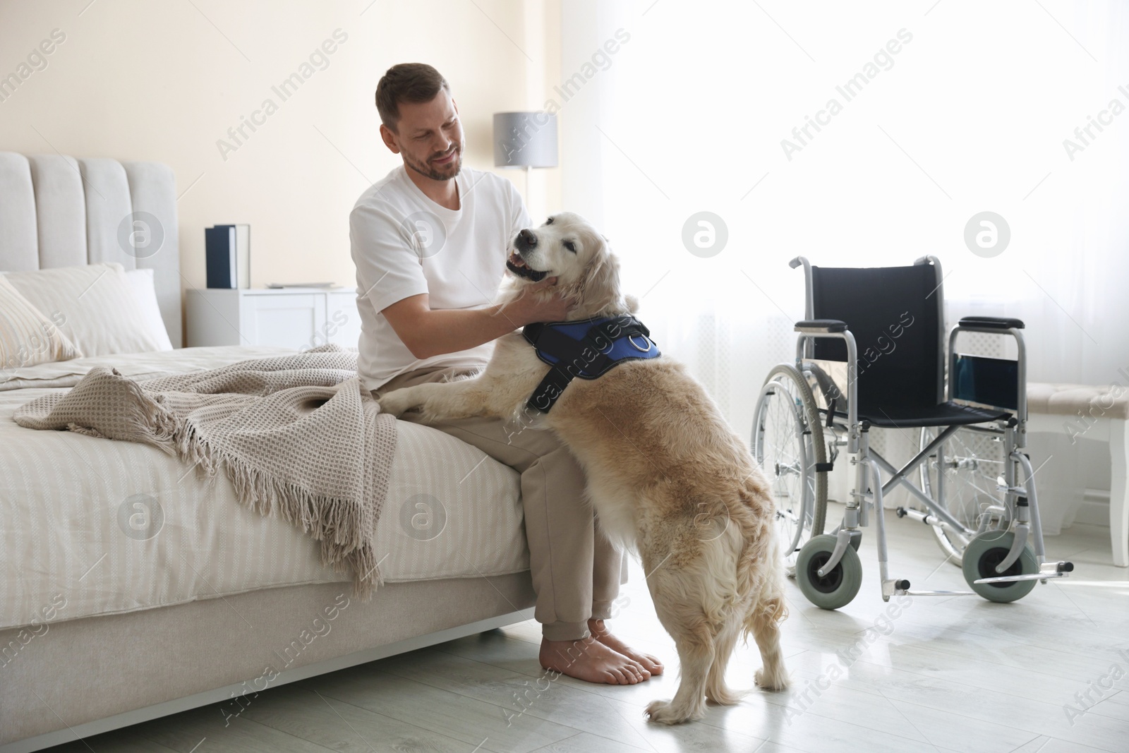 Man with disability and his service dog at home Photo of Man with disability and his service dog at home