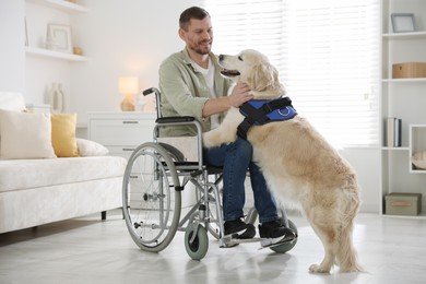 Photo of Man in wheelchair with his service dog at home