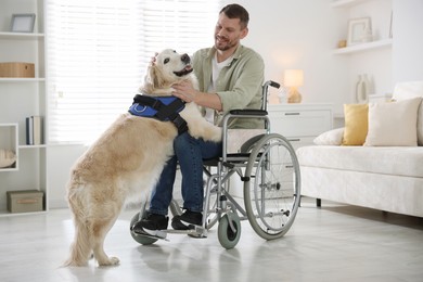 Photo of Man in wheelchair with his service dog at home