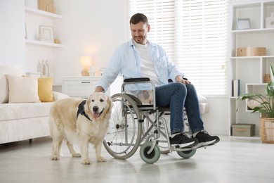 Photo of Man in wheelchair with his service dog at home