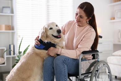 Photo of Woman in wheelchair hugging her service dog at home