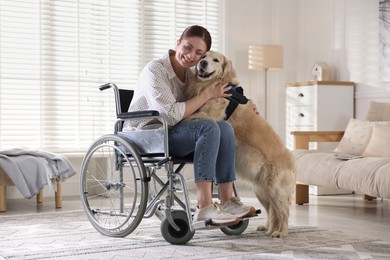 Photo of Woman in wheelchair hugging her service dog at home