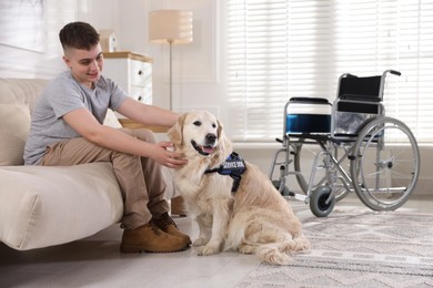 Photo of Teenage boy with disability and his service dog at home