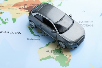 Photo of Road trip concept. Toy car on world map, above view