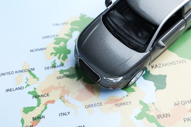 Photo of Road trip concept. Toy car on world map, above view