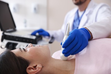 Photo of Sonographer conducting ultrasound examination of woman's thyroid gland in clinic, closeup