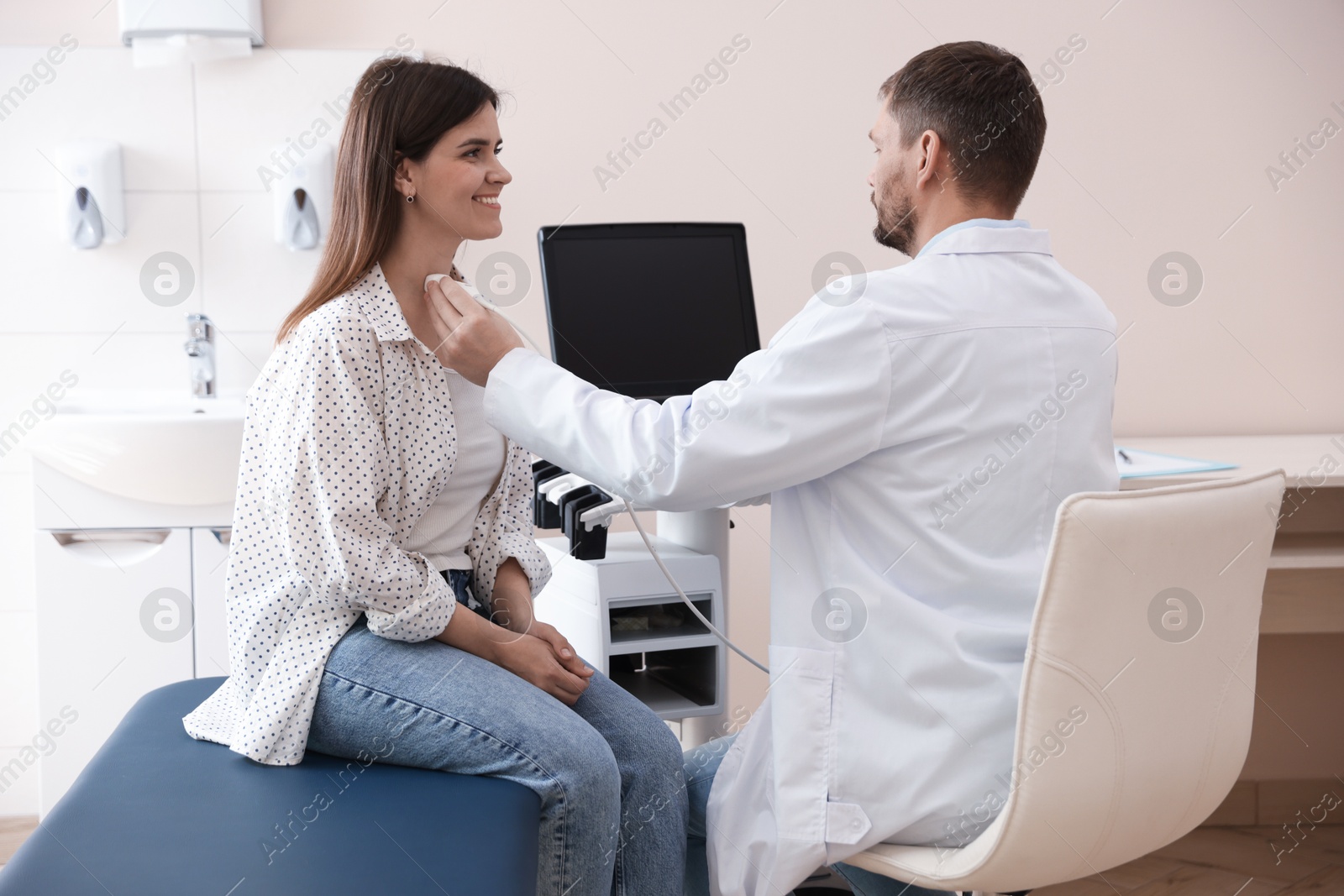 Sonographer conducting ultrasound examination of woman's thyroid gland in clinic Photo of Sonographer conducting ultrasound examination of woman's thyroid gland in clinic