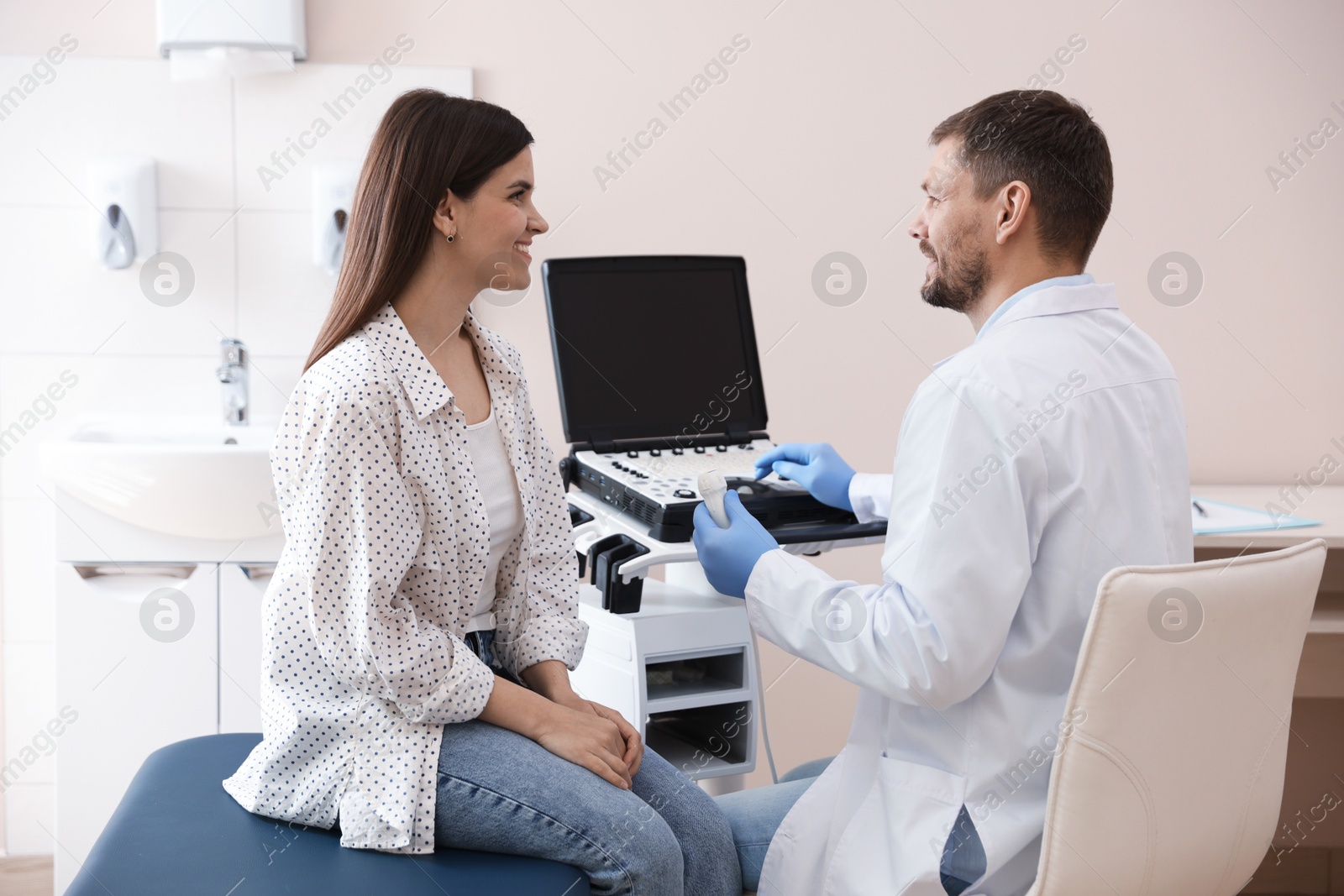 Photo of Sonographer consulting woman before her ultrasound examination in clinic