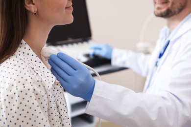 Photo of Sonographer conducting ultrasound examination of woman's thyroid gland in clinic, closeup