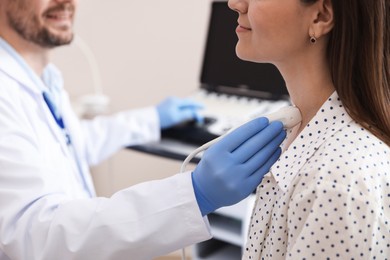 Photo of Sonographer conducting ultrasound examination of woman's thyroid gland in clinic, closeup