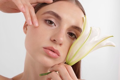 Photo of Portrait of attractive young woman with flower on white background