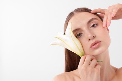Photo of Portrait of attractive young woman with flower on white background. Space for text