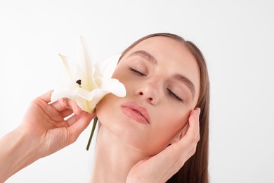 Photo of Portrait of attractive young woman with flower on white background