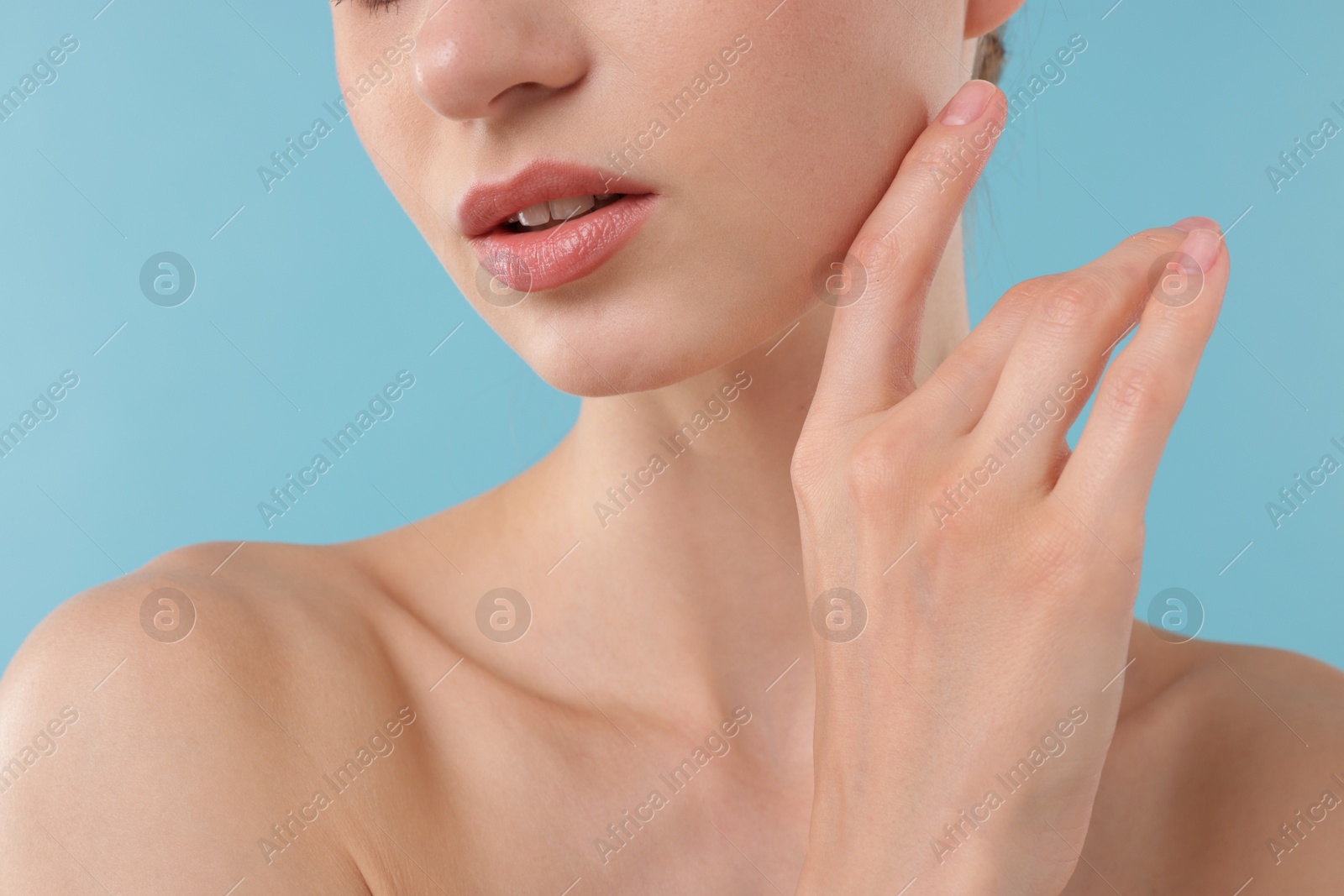 Photo of Beautiful woman posing on light blue background, closeup