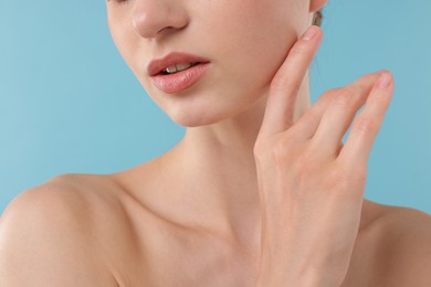 Photo of Beautiful woman posing on light blue background, closeup