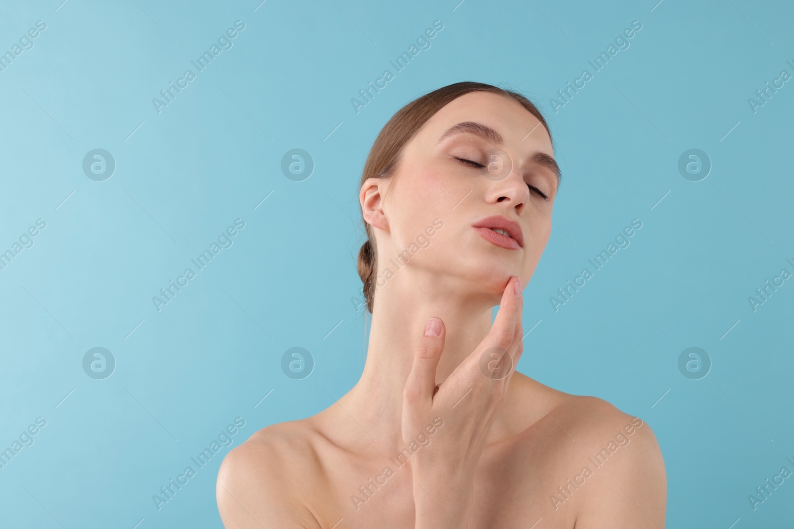 Photo of Portrait of charming young woman on light blue background. Space for text