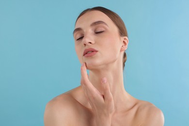 Photo of Portrait of charming young woman on light blue background