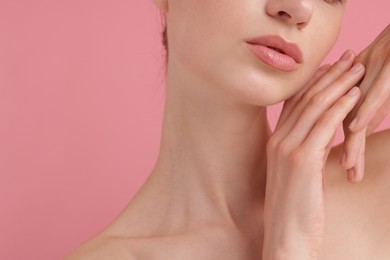Photo of Beautiful woman posing on pink background, closeup
