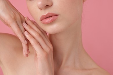 Photo of Beautiful woman posing on pink background, closeup