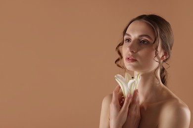 Photo of Portrait of beautiful young woman with flower on beige background. Space for text