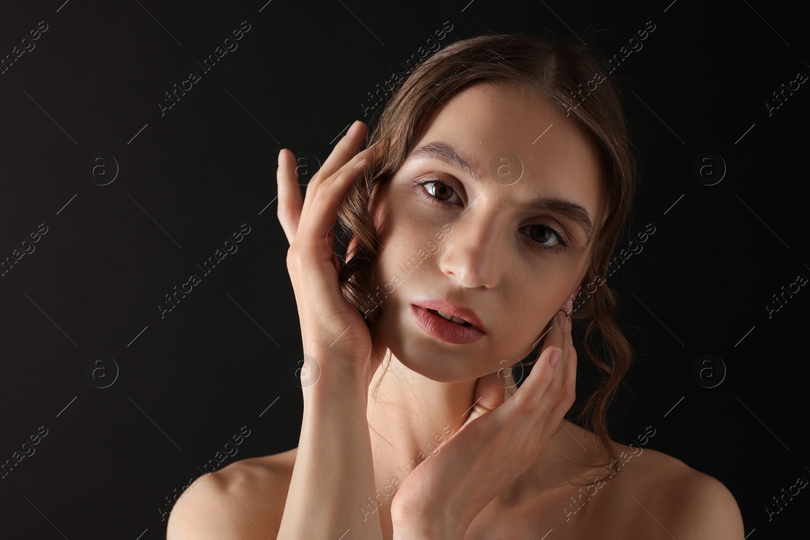 Portrait of gorgeous young woman on black background Photo of Portrait of gorgeous young woman on black background