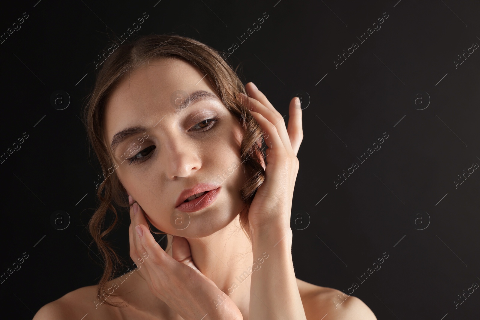 Portrait of gorgeous young woman on black background Photo of Portrait of gorgeous young woman on black background