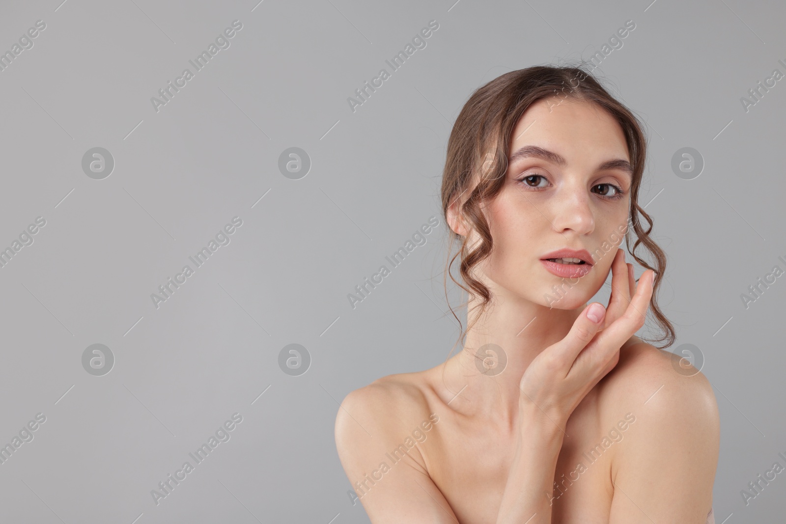 Photo of Portrait of attractive young woman on light grey background. Space for text
