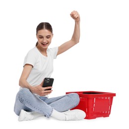 Photo of Woman with plastic shopping basket and smartphone on white background