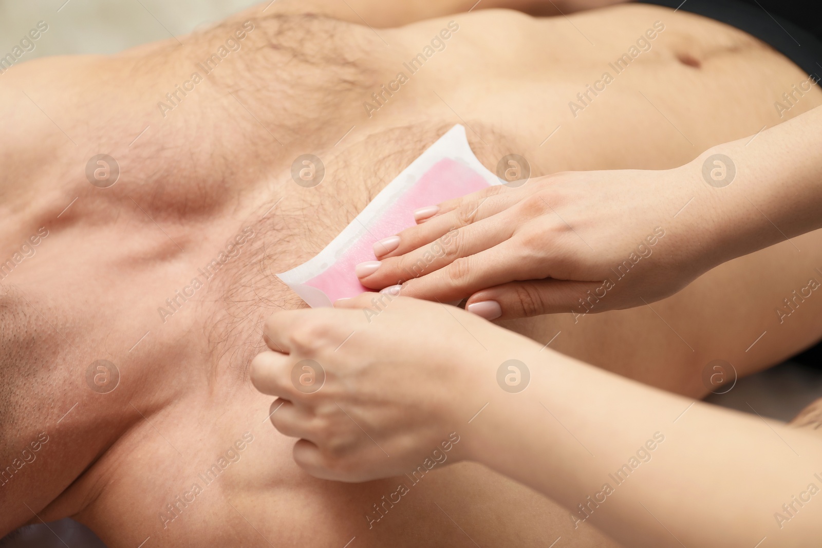 Young man undergoing wax epilation in salon, closeup Photo of Young man undergoing wax epilation in salon, closeup