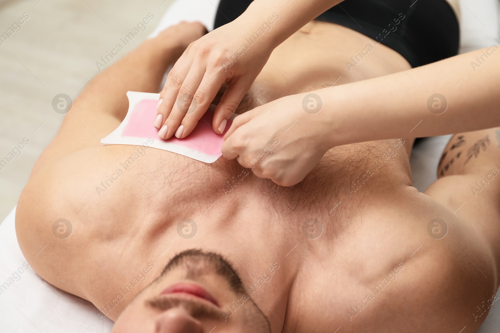 Young man undergoing wax epilation in salon, closeup Photo of Young man undergoing wax epilation in salon, closeup