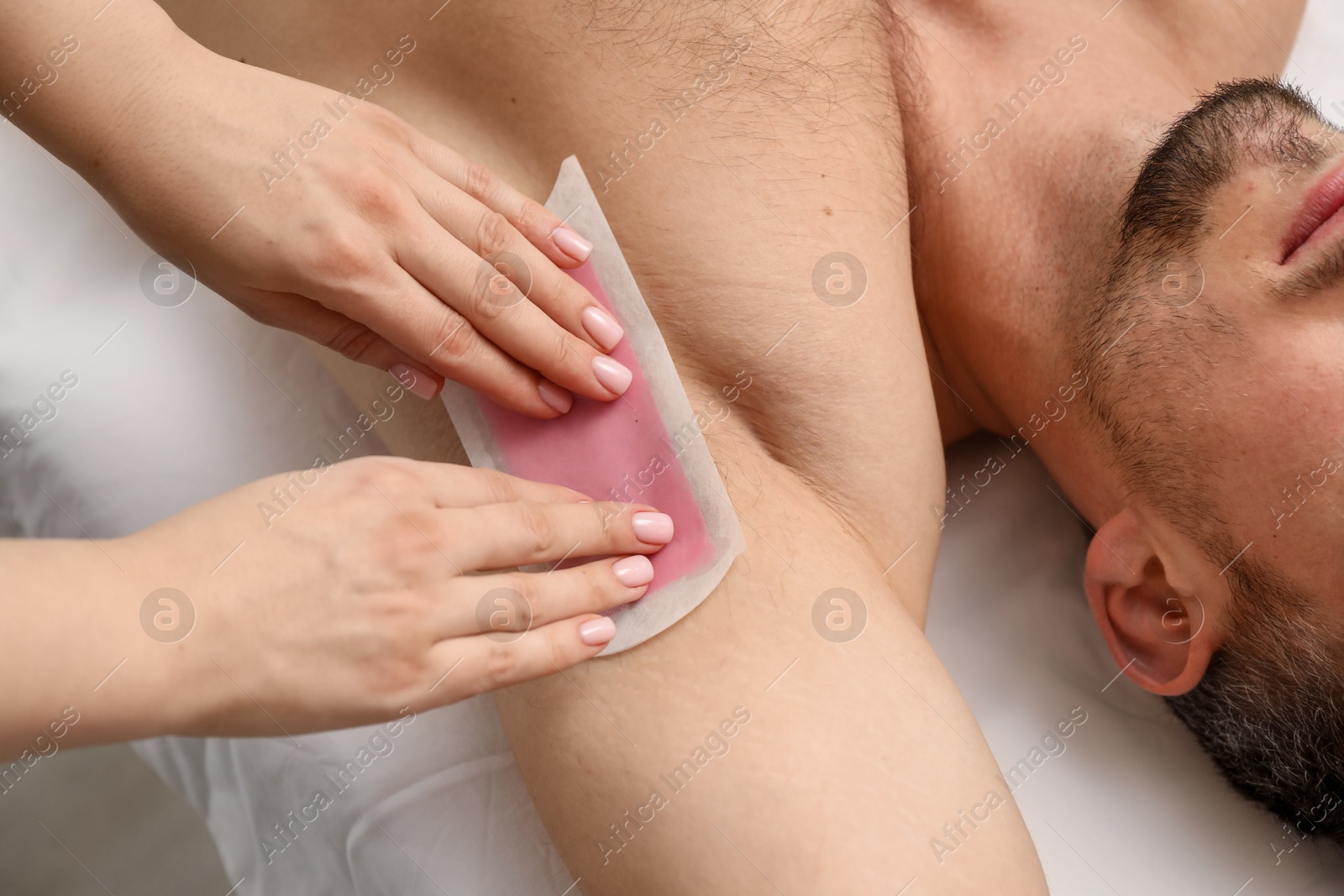 Young man undergoing wax epilation in salon, closeup Photo of Young man undergoing wax epilation in salon, closeup