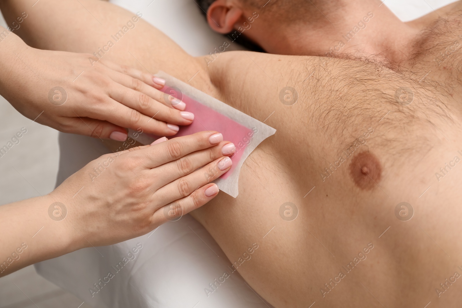 Young man undergoing wax epilation in salon, closeup Photo of Young man undergoing wax epilation in salon, closeup