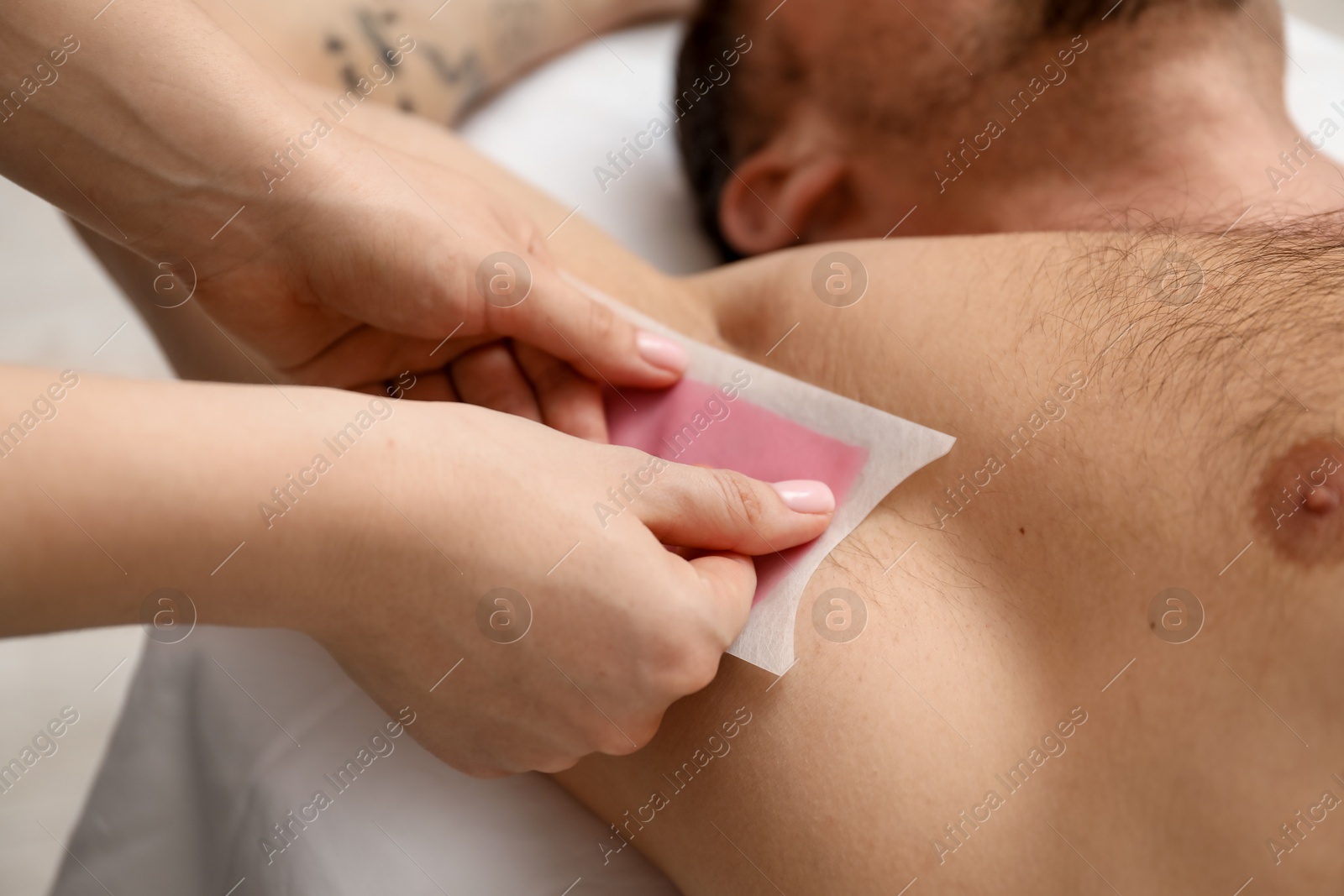 Young man undergoing wax epilation in salon, closeup Photo of Young man undergoing wax epilation in salon, closeup